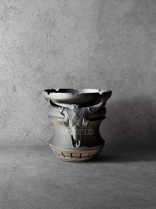 Vesseld.com 3D Printed Black Cylindrical Planter with skull design on a concrete background