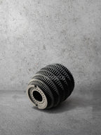 Vesseld.com Bottom of 3D Printed Textured Design Black Cylindrical Planter on a gray concrete background