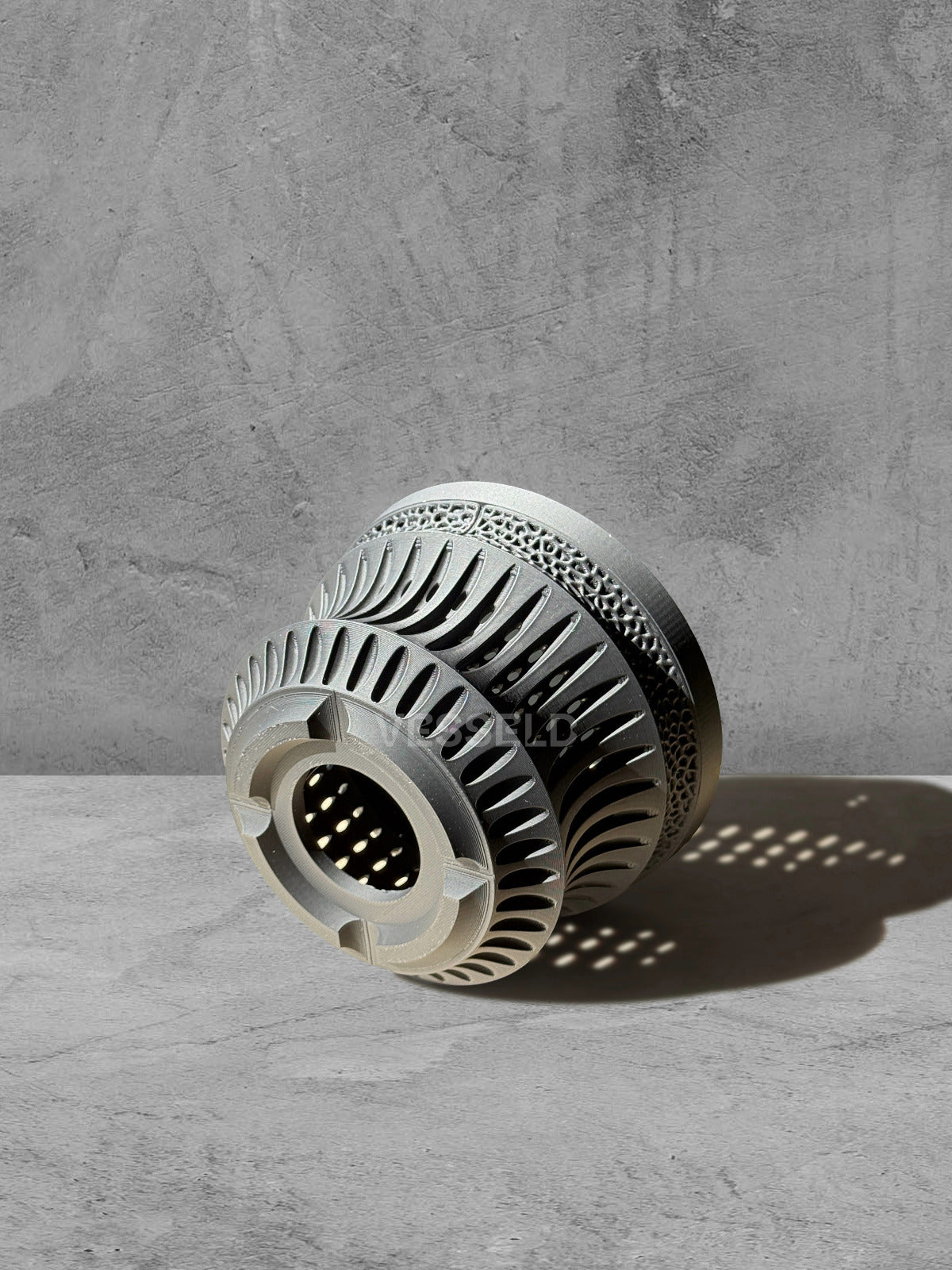 Vesseld.com Bottom of 3D Printed Pot with textured design on a gray surface