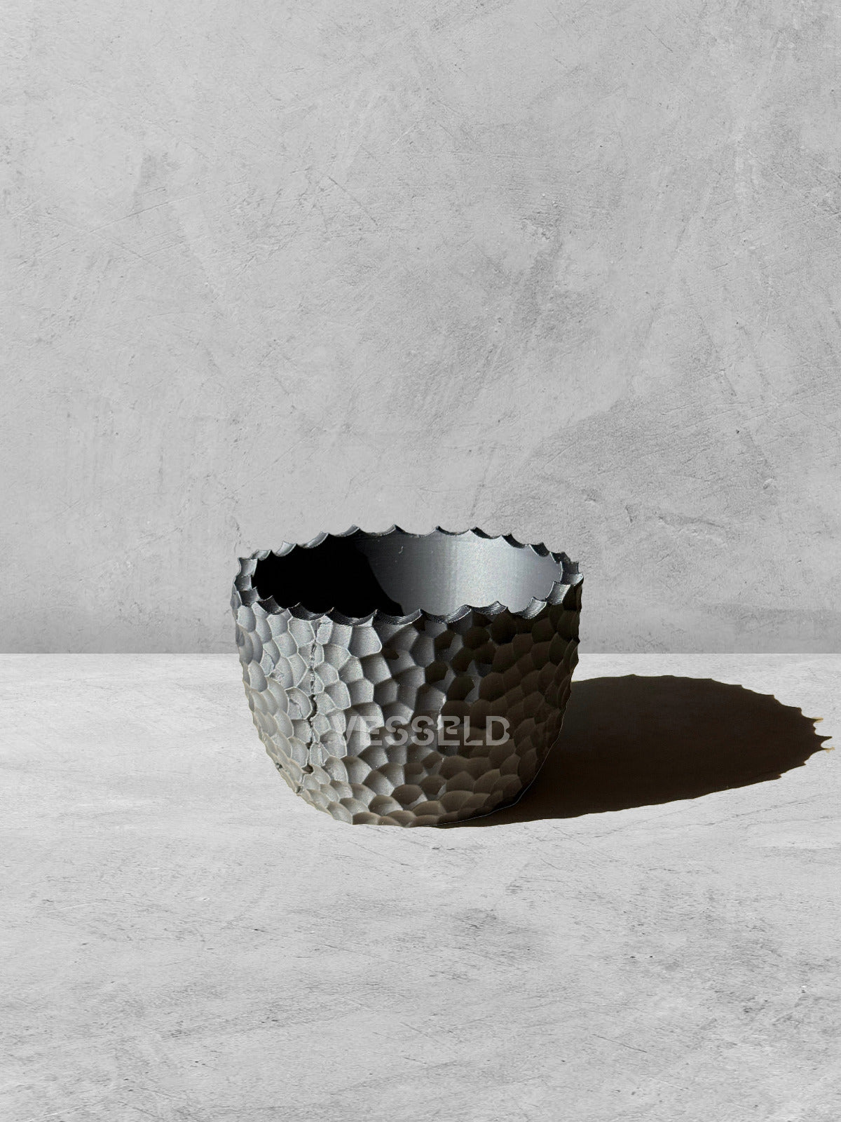 Vesseld.com 3D Printed Textured Black Planter on a gray surface