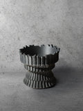 Vesseld.com 3D Printed Textured Black Cylindrical Planter on a concrete background