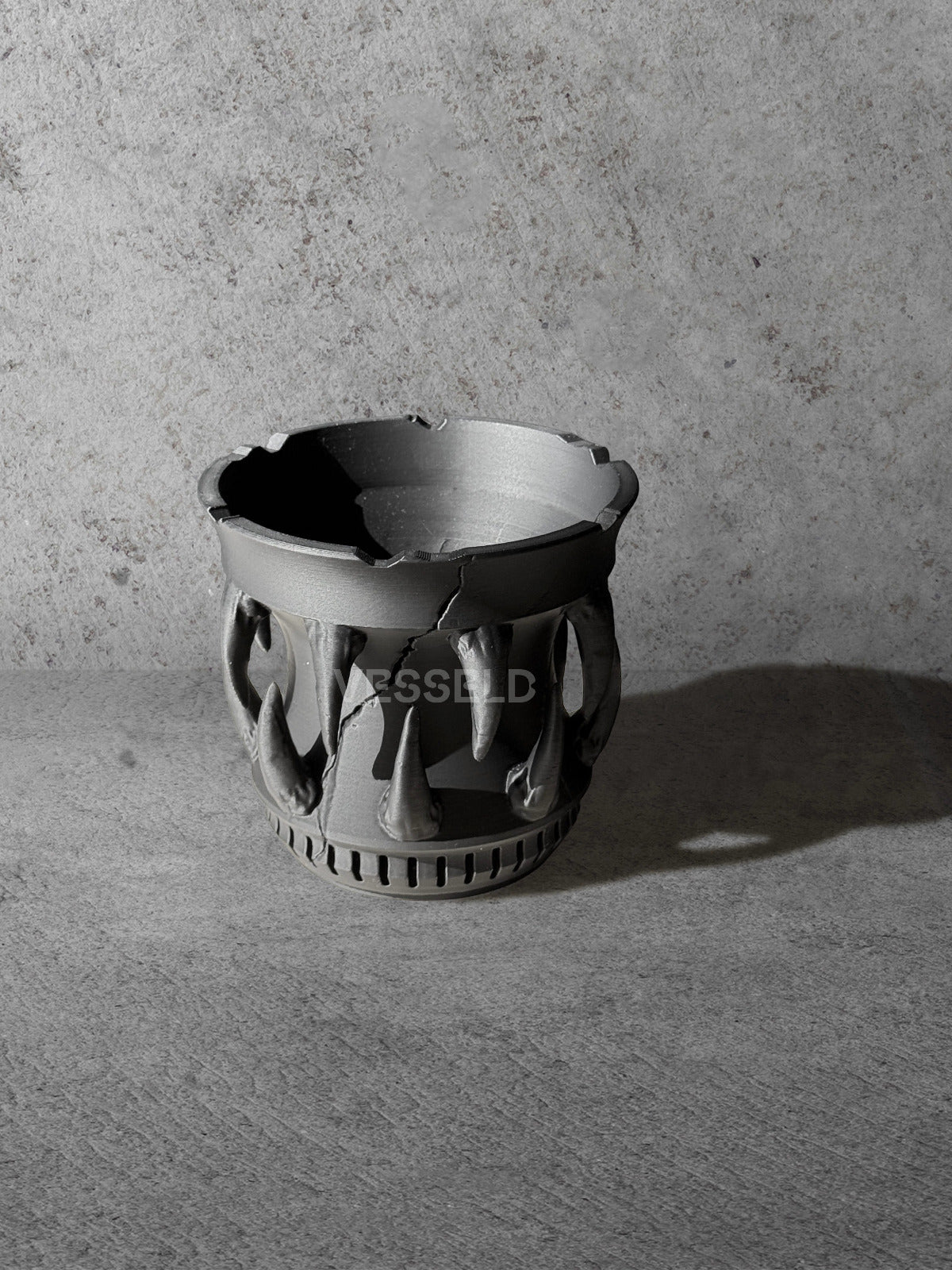 Vesseld.com 3D Printed Black Planter with fangs on a gray surface